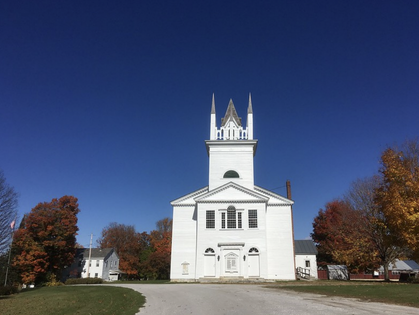 A view of the Sudbury meeting house from the front on a clear blue day